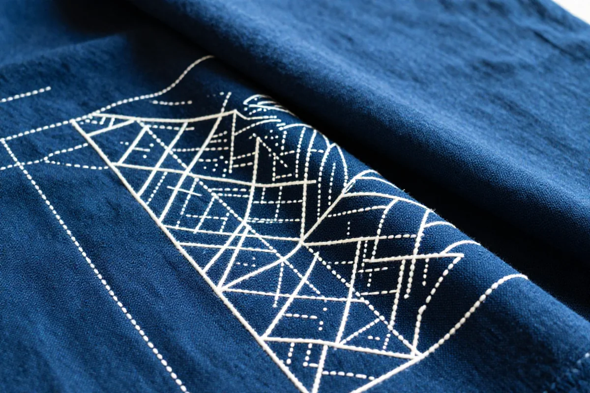 Blisko ujęcie tkaniny haftowanej techniką sashiko z geometrycznymi wzorami